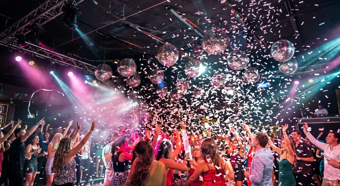 Lluvia de papel en una fiesta con luces y bolas de disco
